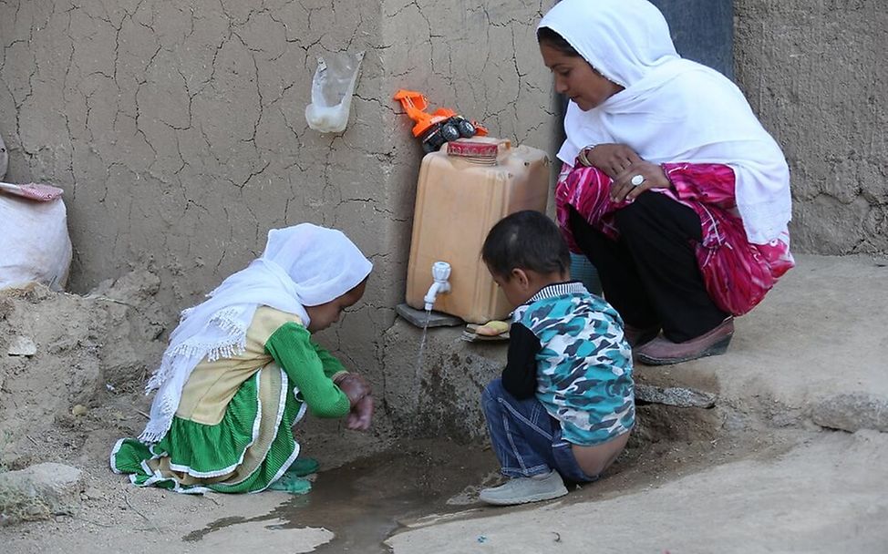 Afghanistan: Eine Mutter und ihre zwei Kinder waschen sich die Hände.