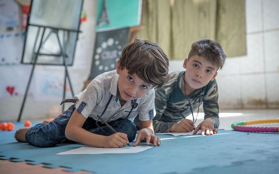 Irak: Die Freunde Raja und Abdulrahman freuen sich, in Ruhe spielen und malen zu können. 