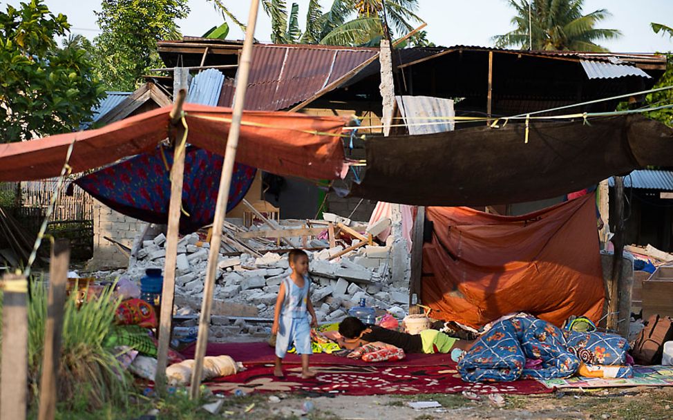 Indonesien: Junge vor dem durch das Erdbeben zerstörten Haus seiner Familie in Palu 