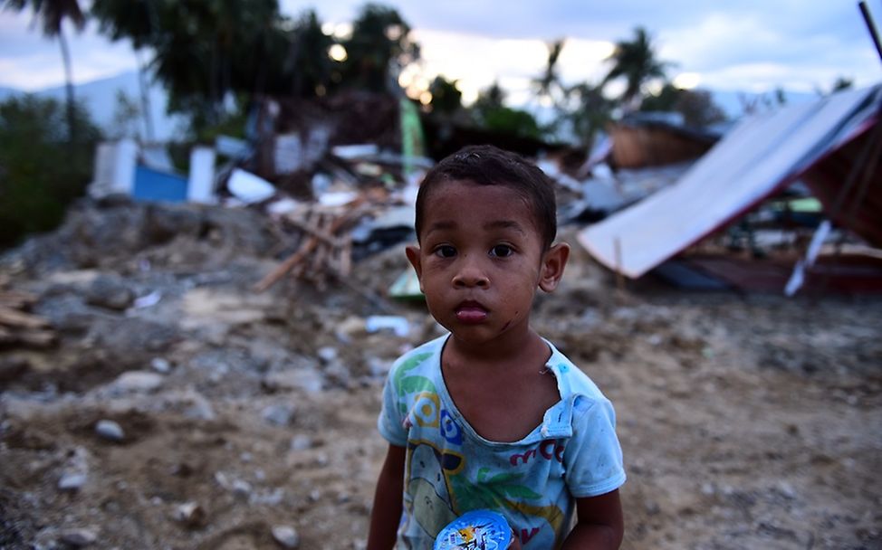 Indonesien: Junge vor den Trümmern eines Hauses