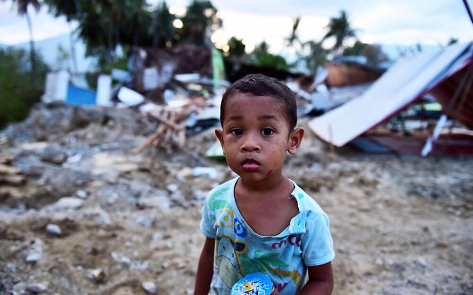 Nach dem Tsunami auf Indonesien steht der zweijährige Muhamad vor den Ruinen seines Hauses. 