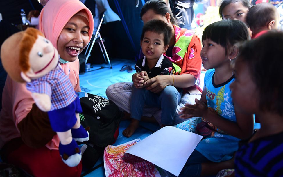 Tsunami in Indonesien: Eine Helfern zeigt Kindern ein Puppenspiel