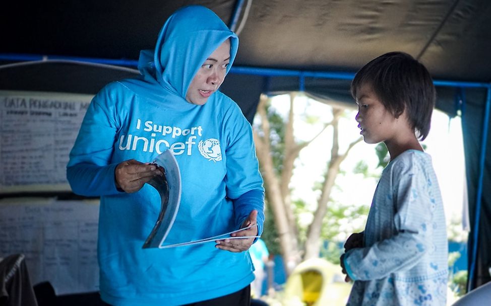 Ein Junge erhält psychosoziale Unterstützung einer UNICEF-Kinderschutbeauftragten. 