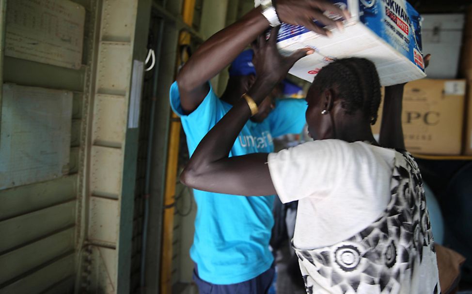 Südsudan: Ein UNICEF-Mitarbeiter übergibt einen Karton mit Hilfsgütern