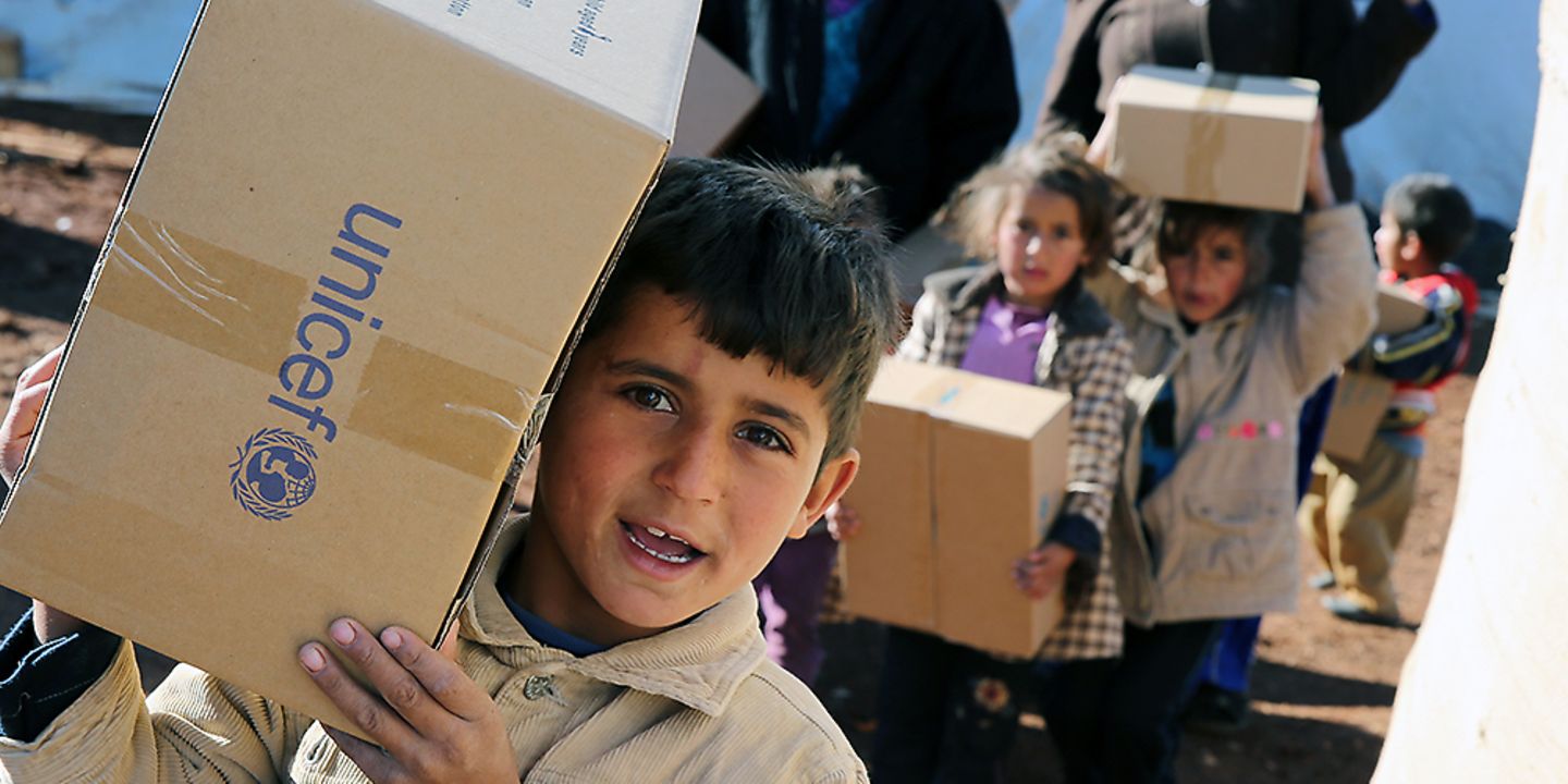 Der Weg der Spende: Junge trägt UNICEF-Kiste