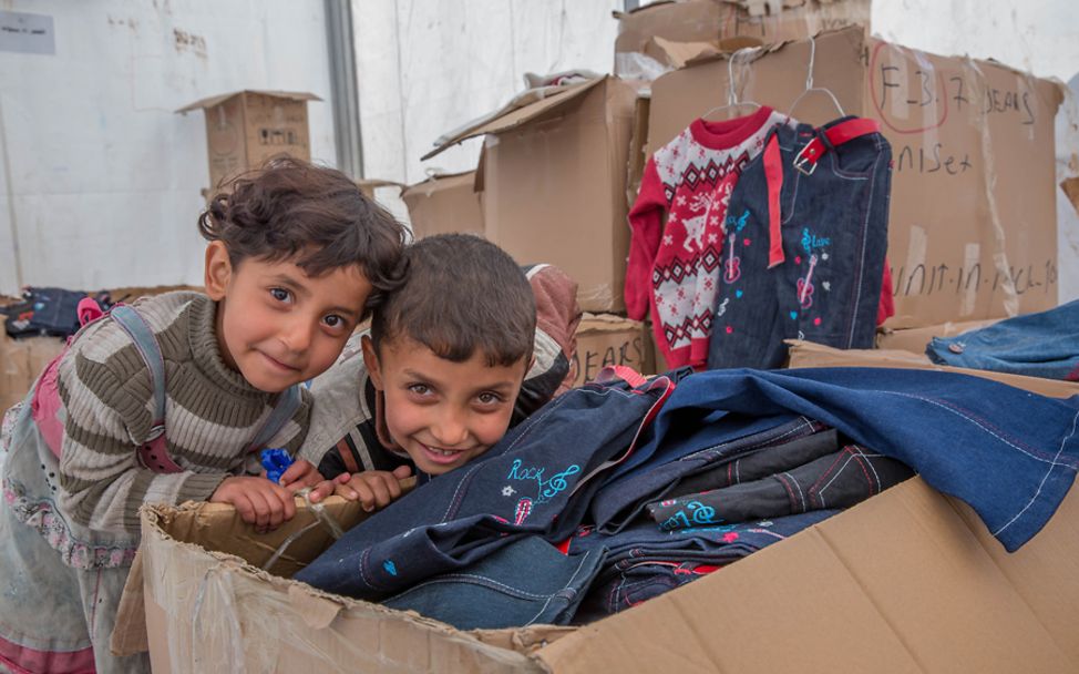 Spenden Weihnachten: Zwei irakische Flüchtlingsjungen mit einem UNICEF-Winterhilfspaket 