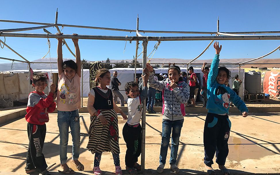 Libanon: Kinder schaukeln an Zeltstangen.