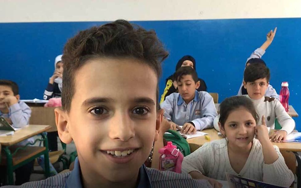 Libanon: Hamzah sitzt glücklich in seiner Klasse.