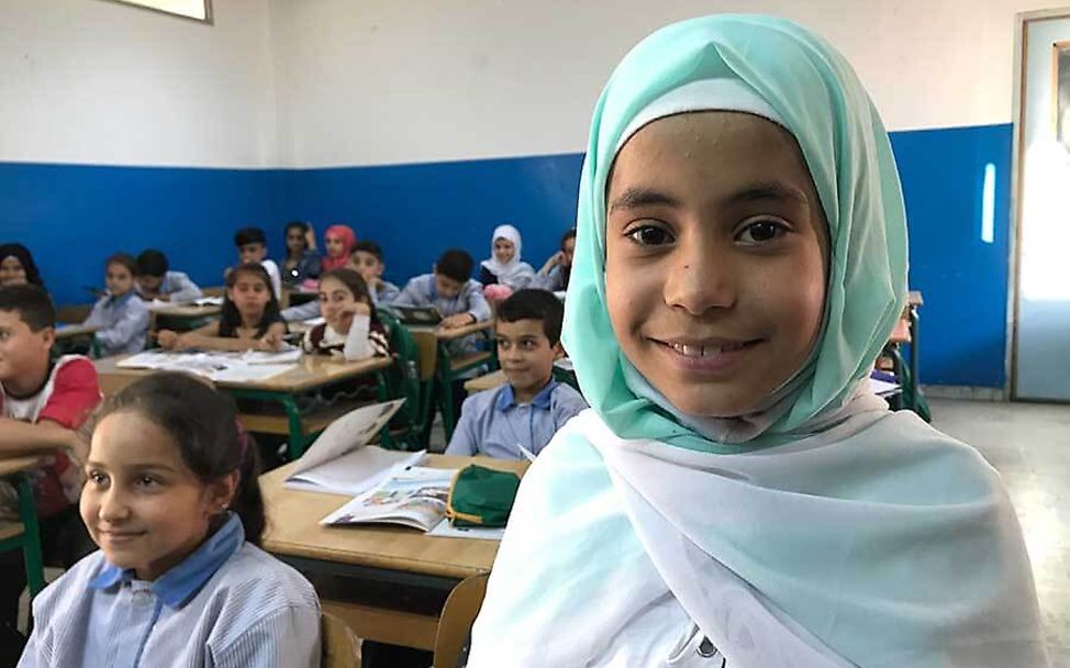Libanon: Rama steht lächelnd in ihrer Klasse.