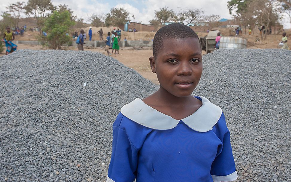 Malawi: Aness steht vor der Schulbaustelle. 