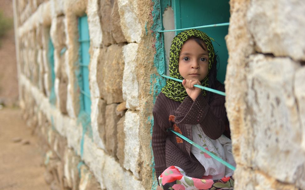 Drohende Hungersnot im Jemen: Die dreijährige Monira sitzt erholt auf einer Mauer.