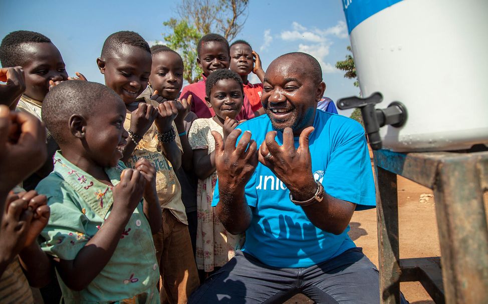 Kongo: UNICEF-Helfer zeigt Kindern, wie man sich die Hände wäscht