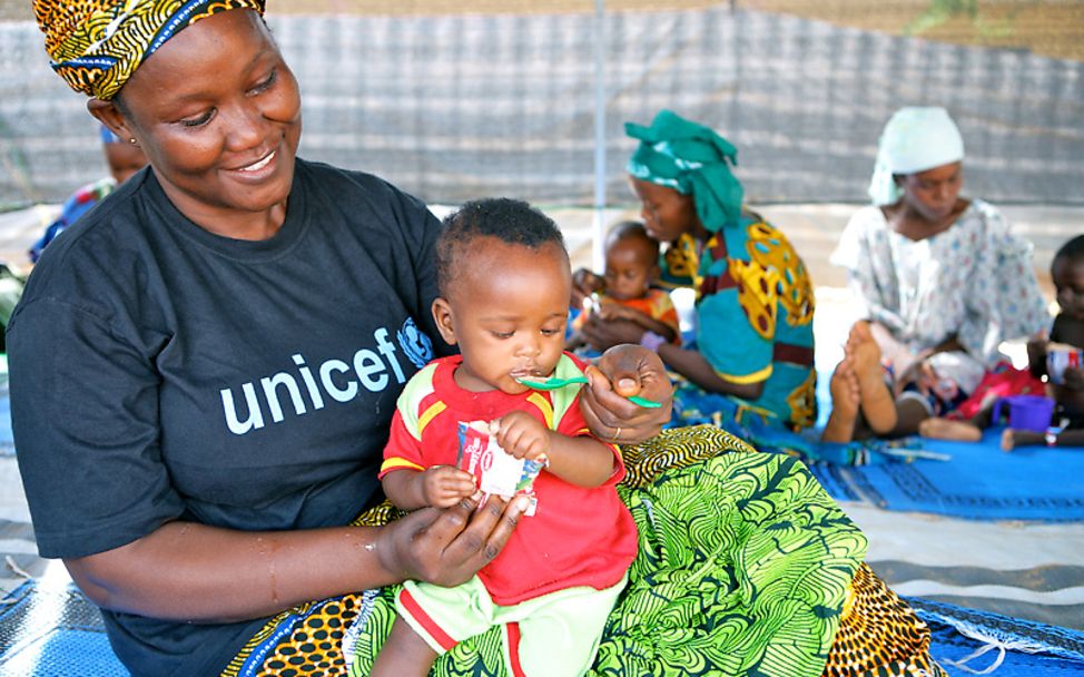 Niger: Eine UNICEF-Helferin füttert ein Baby mit Erdnusspaste