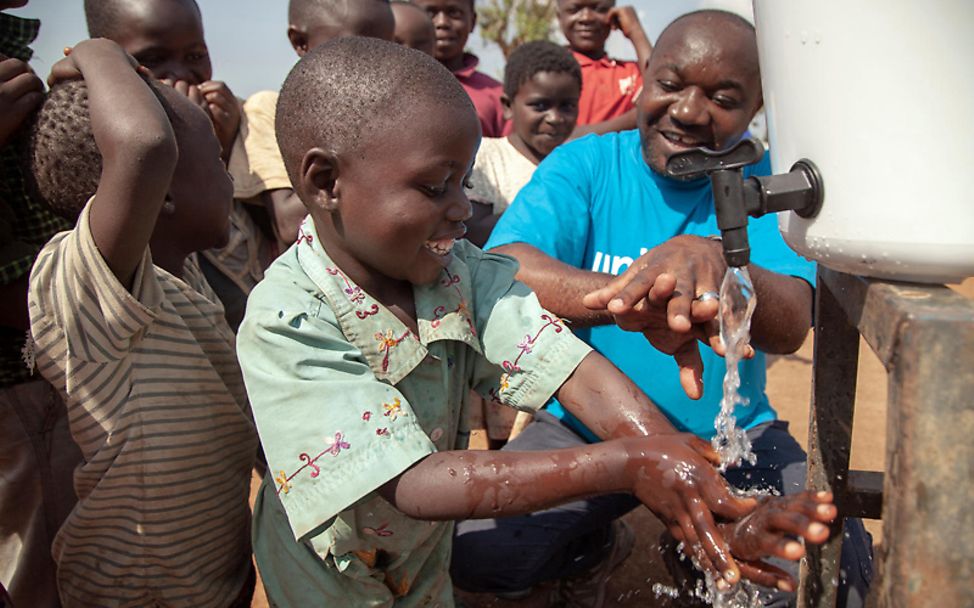 Kongo: UNICEF-Mitarbeiter zeigt Kindern, wie sie sich die Hände waschen