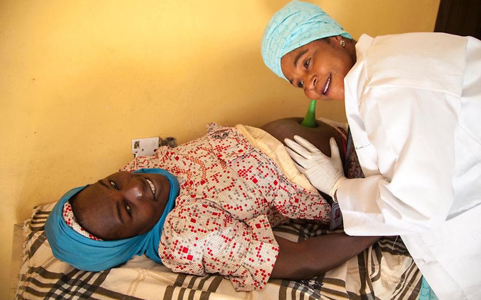 Nigeria: Eine Hebamme untersucht eine schwangere Frau