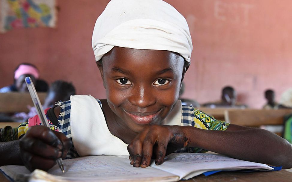 Elfenbeinküste: Ein Mädchen mit Heft und Stift im Unterricht.