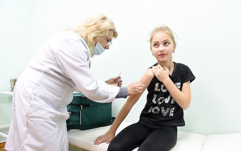 Ukraine: Ein neun-jähriges Mädchen wird von einer Ärztin geimpft.