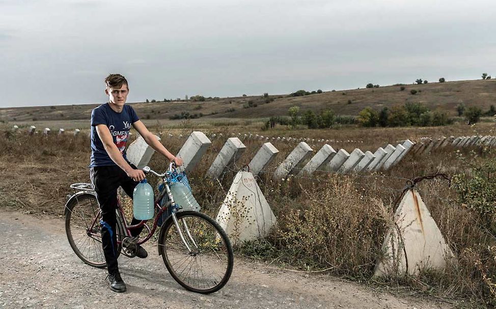 Mit dem Fahrrad transportiert Dima Wasser nach Hause. 