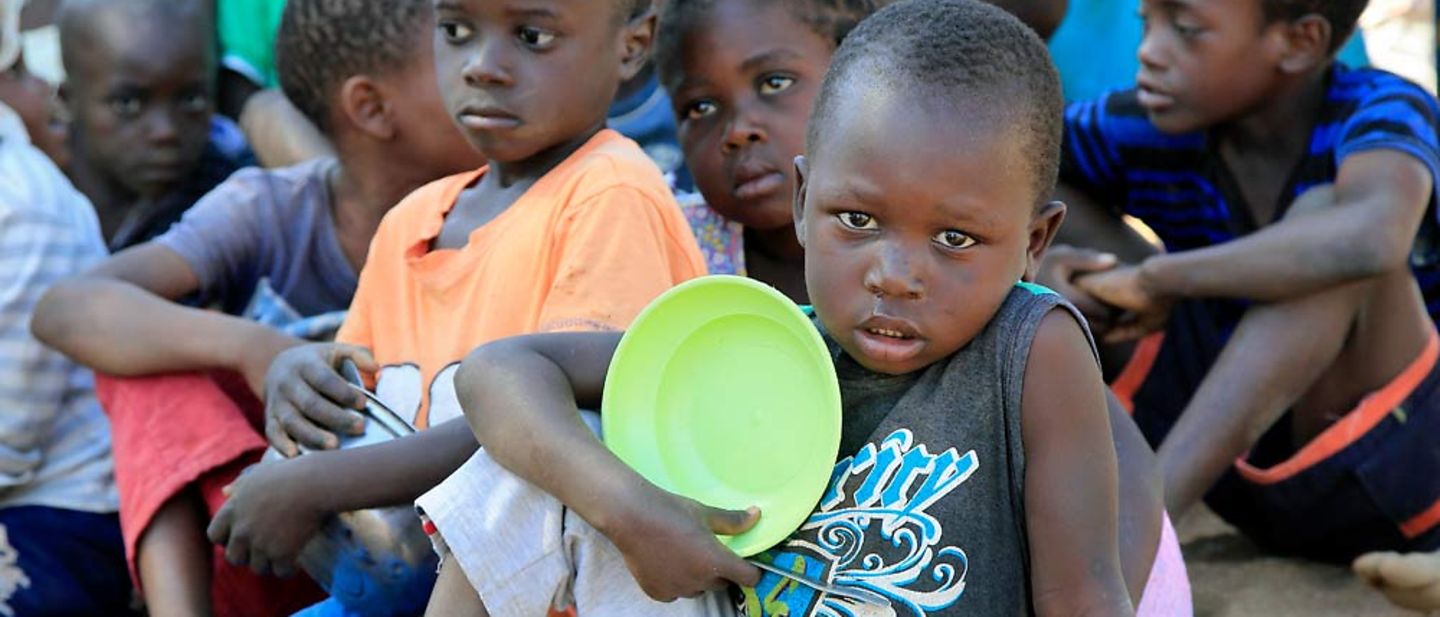 Mosambik: Spenden für Kinder in Not. Junge mit leerem Teller in der Hand