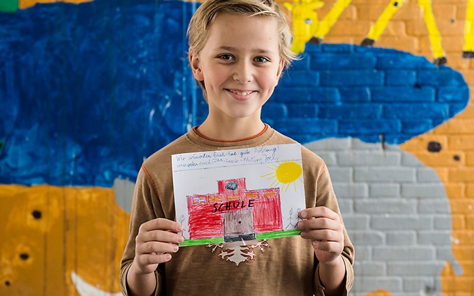 Münster: Ein Schüler zeigt sein Bild zum Aktionstag Kinderrechte.