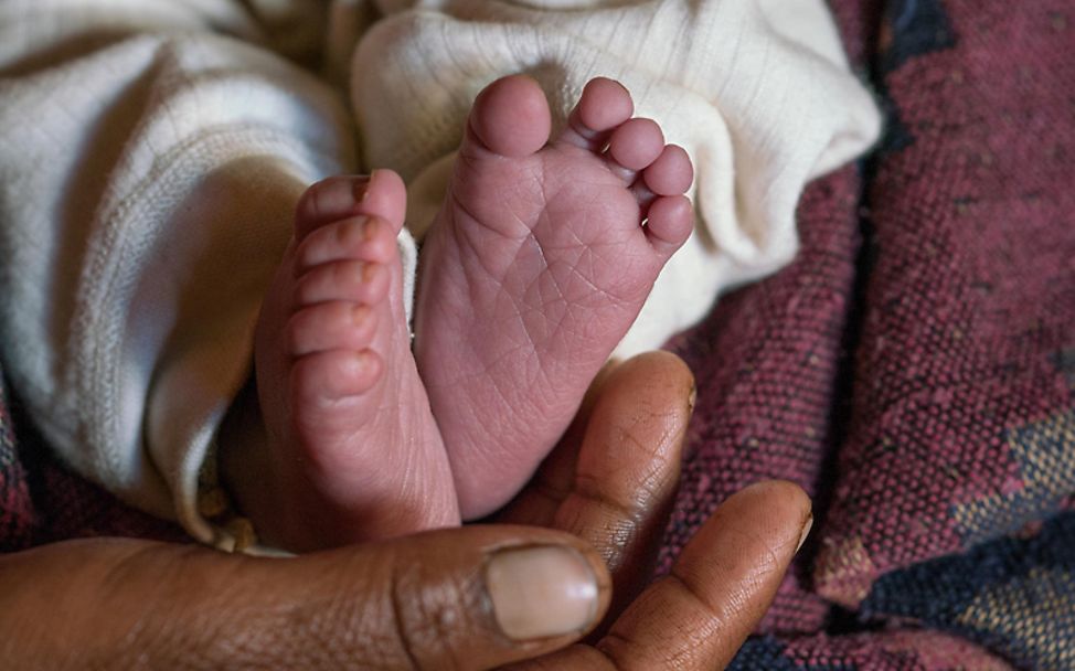Mütter in aller Welt: Eine Mutter hält liebevoll die Füße ihres Babys