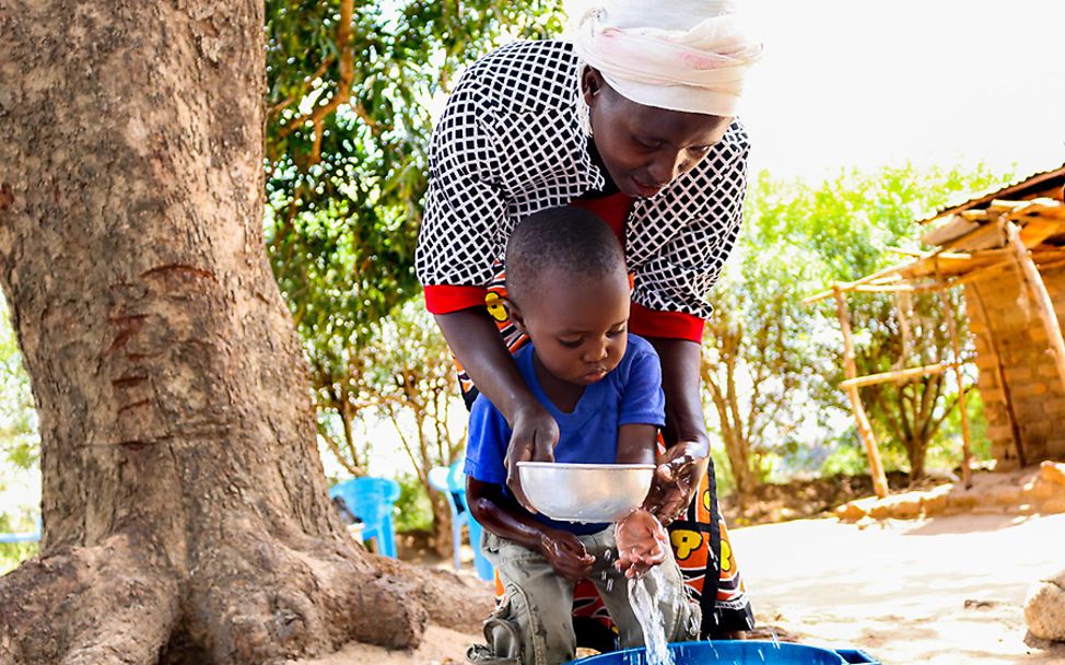 Kenia: Anastasia wäscht ihrem zweijährigen Sohn Evans die Hände.