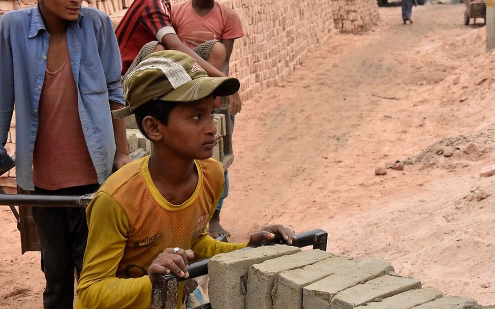 Kinderarbeit in Bangladesch: Mohamed schiebt einen karren mit Steinen.