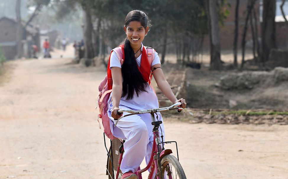 Ein Mädchen fährt mit dem Fahrrad zur Schule