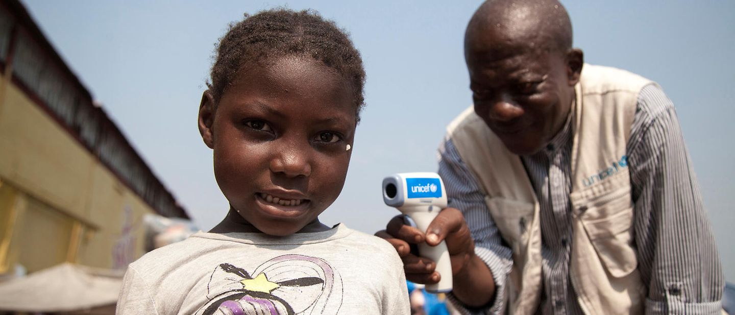 Kongo: Ein UNICEF-Helfer misst die Temperatur eines Mädchens