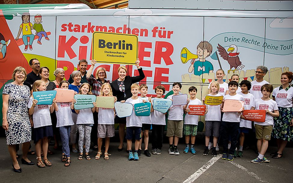 Berlin: Eine Gruppe von Kindern mit Betreuern vor dem Bus der Tour "Stark machen für Kinderrechte"