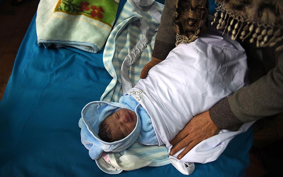 Afghanistan: Baby Rayan wird im Krankenhaus angezogen und in Decken gewickelt.