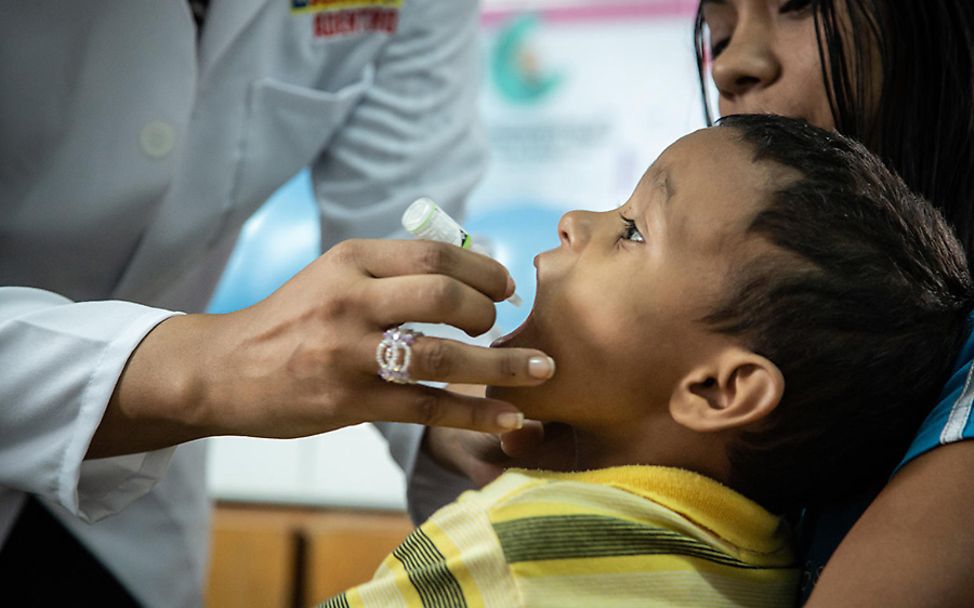 Venezuela: Ein Junge erhält von einer Helferin seine Polio-Impfung.