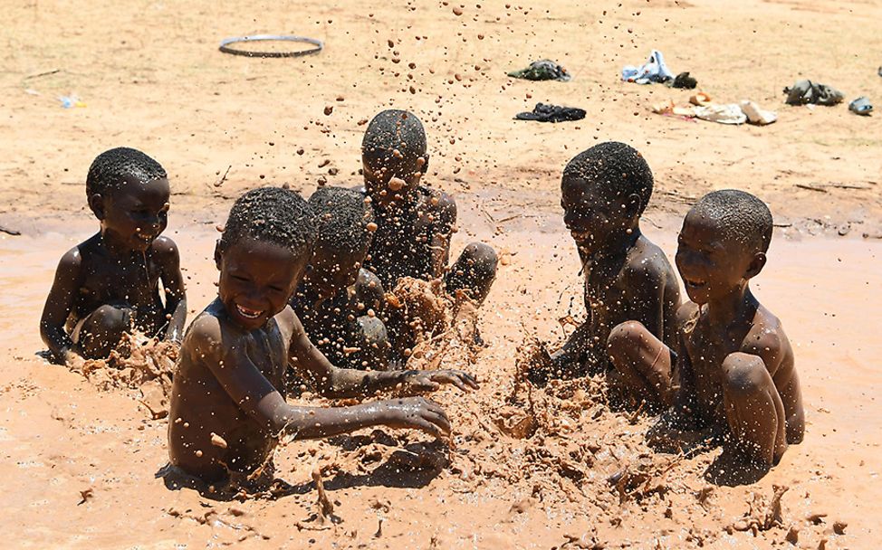 Niger: Eine Gruppe von Jungs spielt im Matsch.