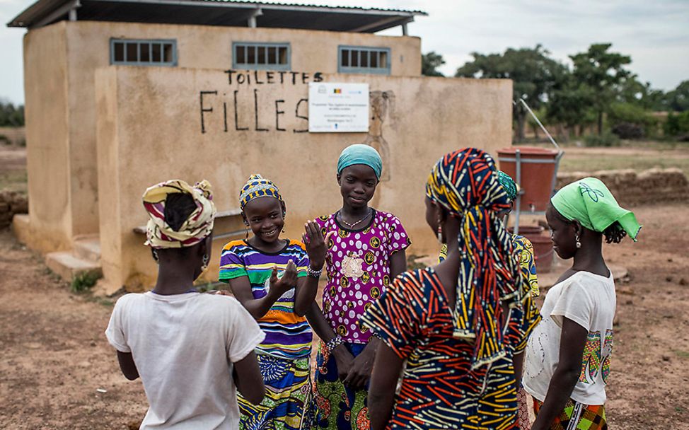 Mali: Eine Gruppe von Mädchen steht vor der Schultoilette.