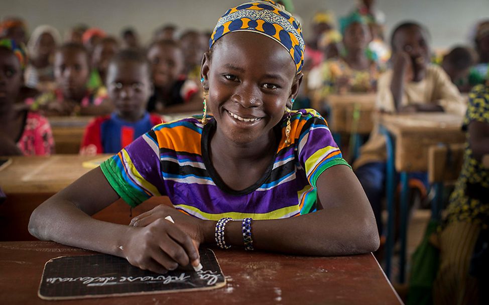 Mali: Die 12-Jährige Fatoumata schreibt mit Kreide auf eine Schiefertafel.