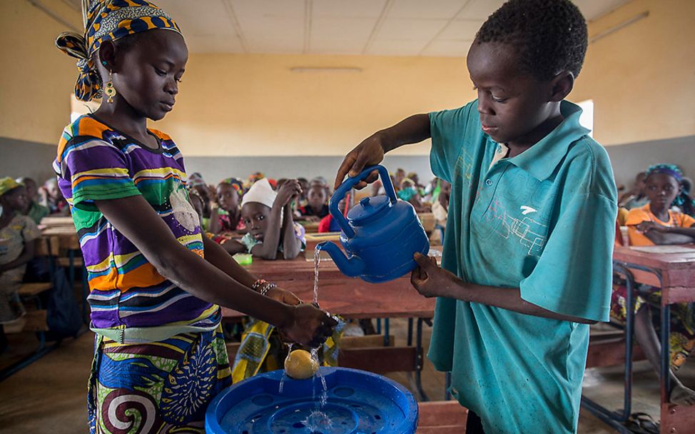 Mali: Fatoumata und ein Klassenkamerad zeigen ihren Mitschülern das richtige Händewaschen.