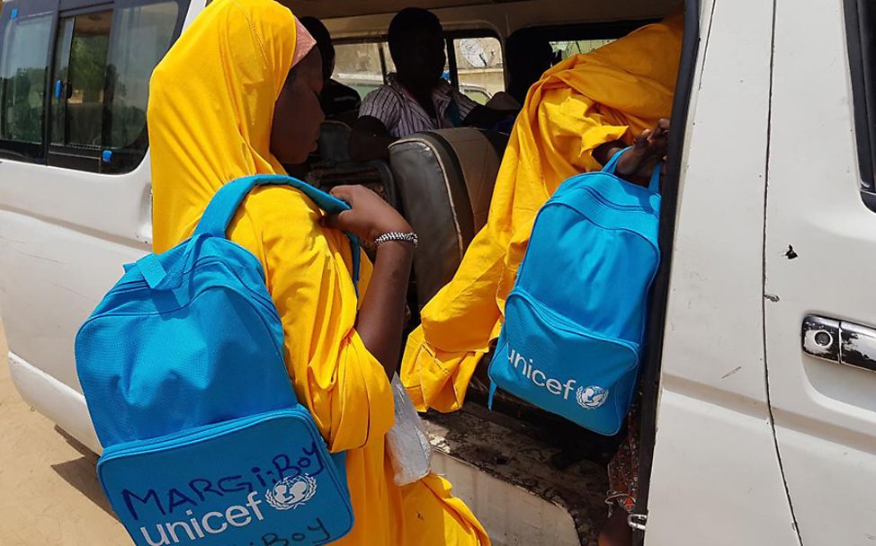 Nigeria: Fati und andere Mädchen steigen mit UNICEF-Rucksäcken in einen Van. 