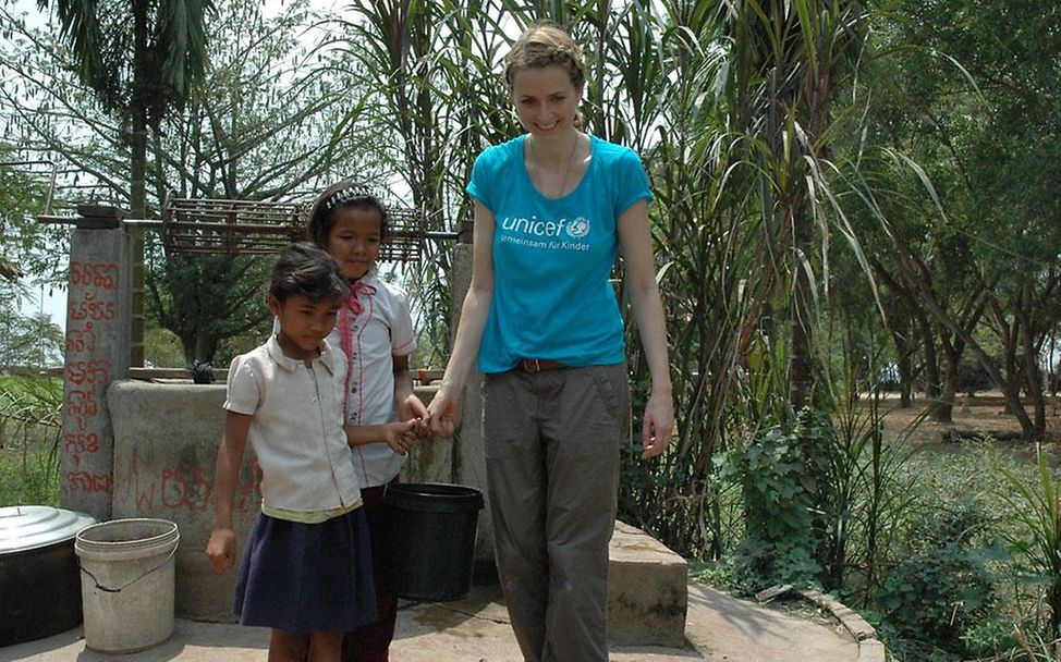 Kambodscha: Eva Padberg hilft zwei Mädchen beim Wasser tragen.