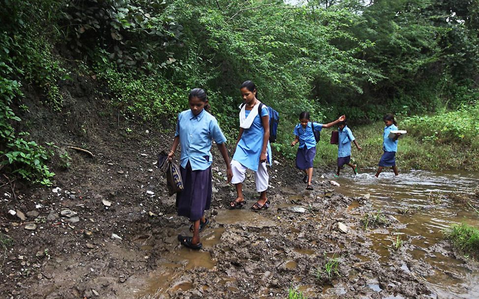 Indien: Schülerinnen waten durch Bäche und Matsch.