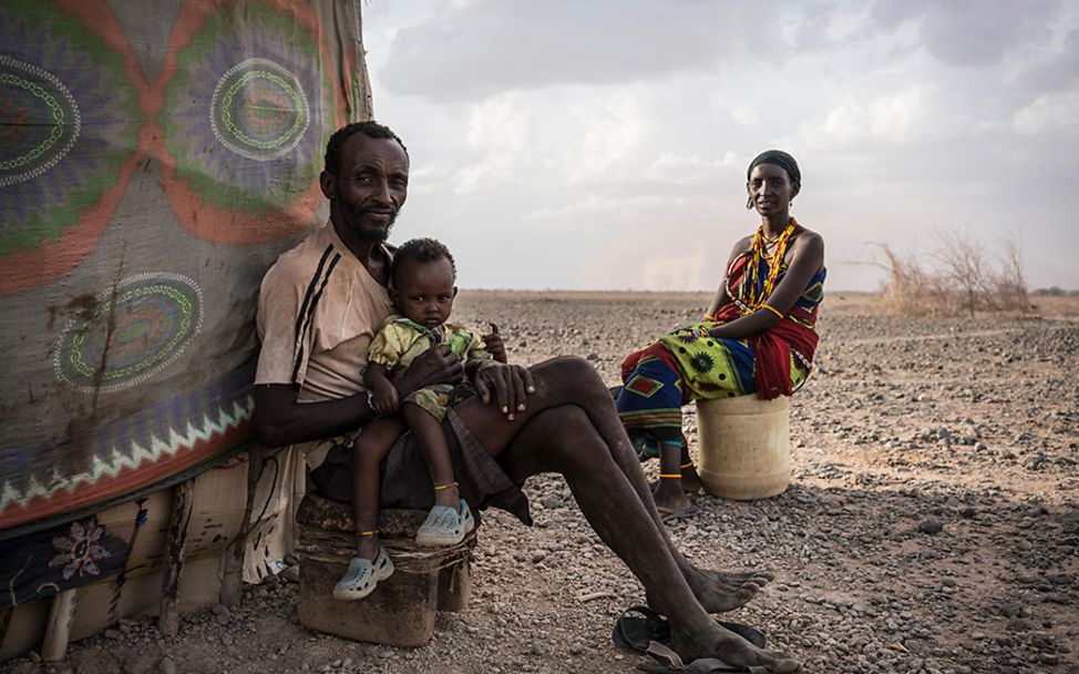 kilmawandel folgen kinder: Ali sitzt mit seiner Tochter und seiner Frau vor ihrem Zelt.