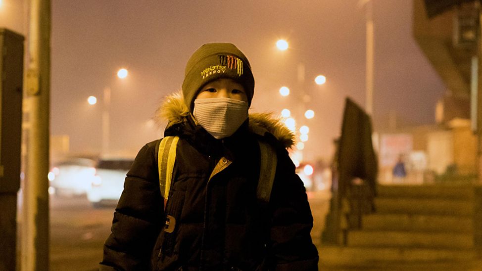 klimawandel folgen kinder: Ein Junge trägt aufgrund der hohen Luftverschmutzung eine Schutzmaske.