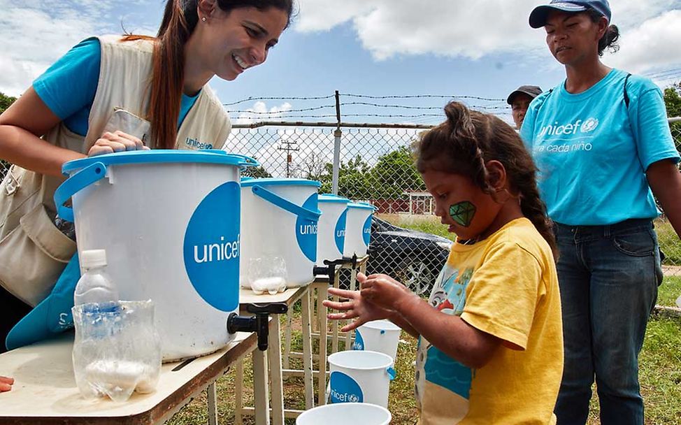 Aufklärung: Eine UNICEF-Mitarbeitern zeigt Kindern, wie sie sich die Hände waschen können.