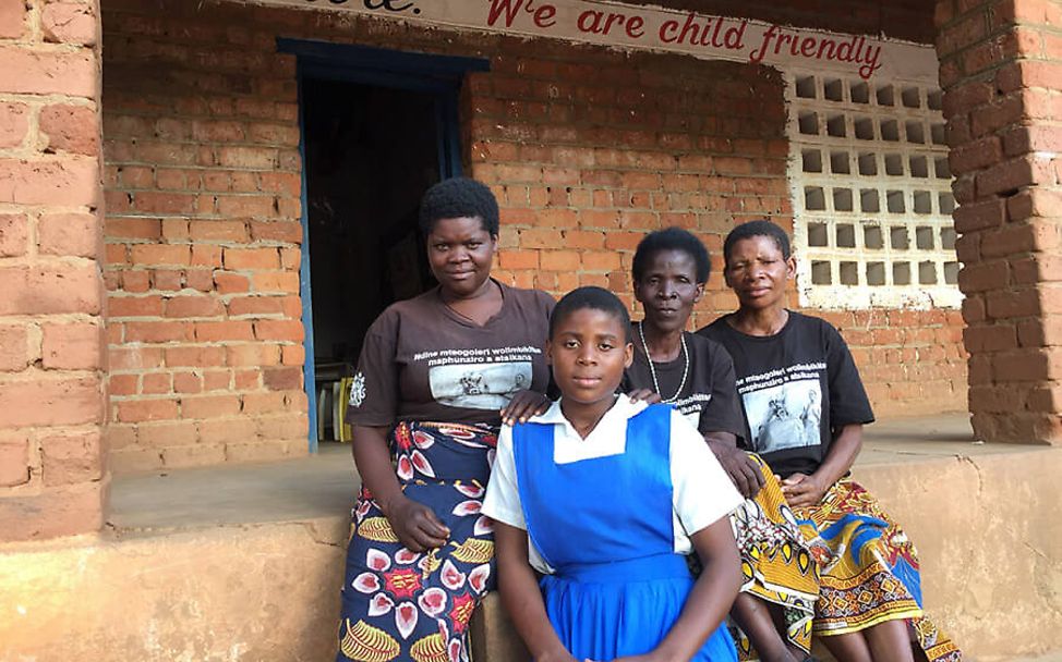 Malawi: Neria in ihrer Schule mit drei Frauen der Müttergruppe