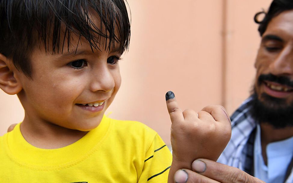 Kindersterblichkeit gesunken: Ein Junge zeigt nach der Impfung seine Fingermarkierung.
