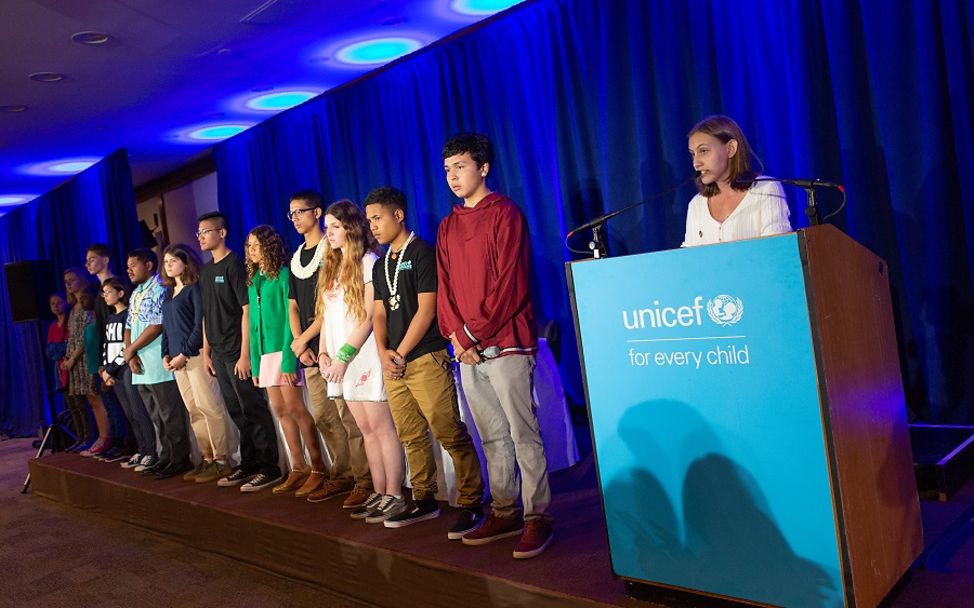 Kinderrechtsbeschwerde: 15 Jugendliche stehen auf dem Podium einer Pressekonferenz.