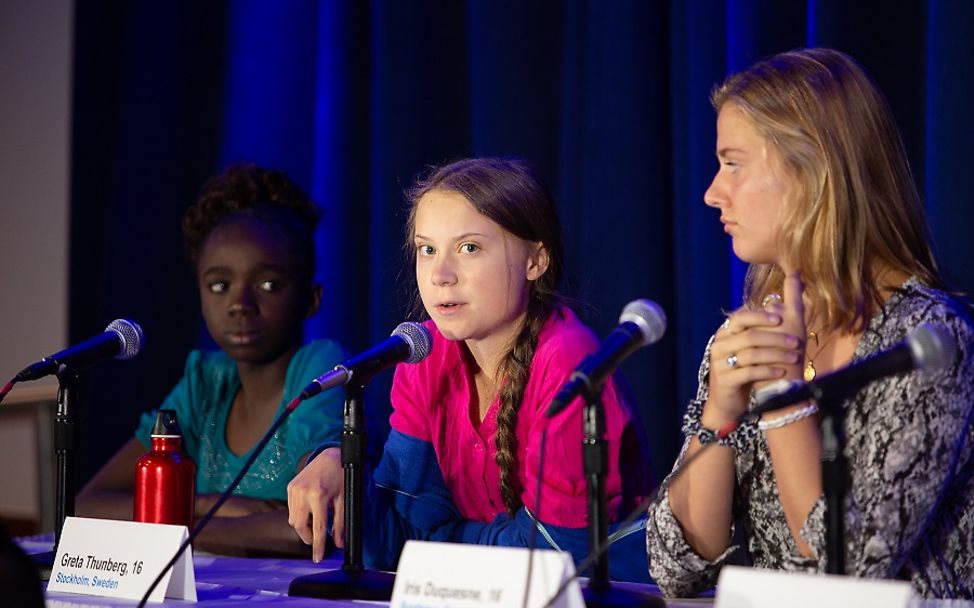 Greta Thunberg spricht neben anderen Jugendlichen auf dem Podium einer Pressekonferenz.