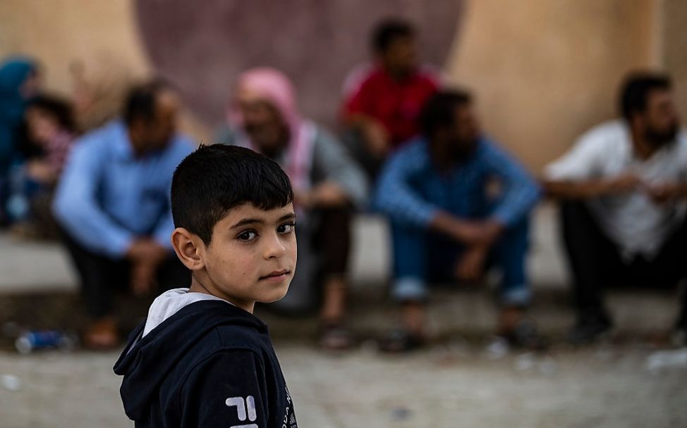 Ein Junge in Syrien auf der Straße schaut traurig in die Kamera.