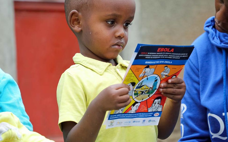 Ebola-Bekämpfung: Ein Junge schaut sich eine Info-Broschüre an. Das Ebola-Fieber wird über Körperflüssigkeiten übertragen.