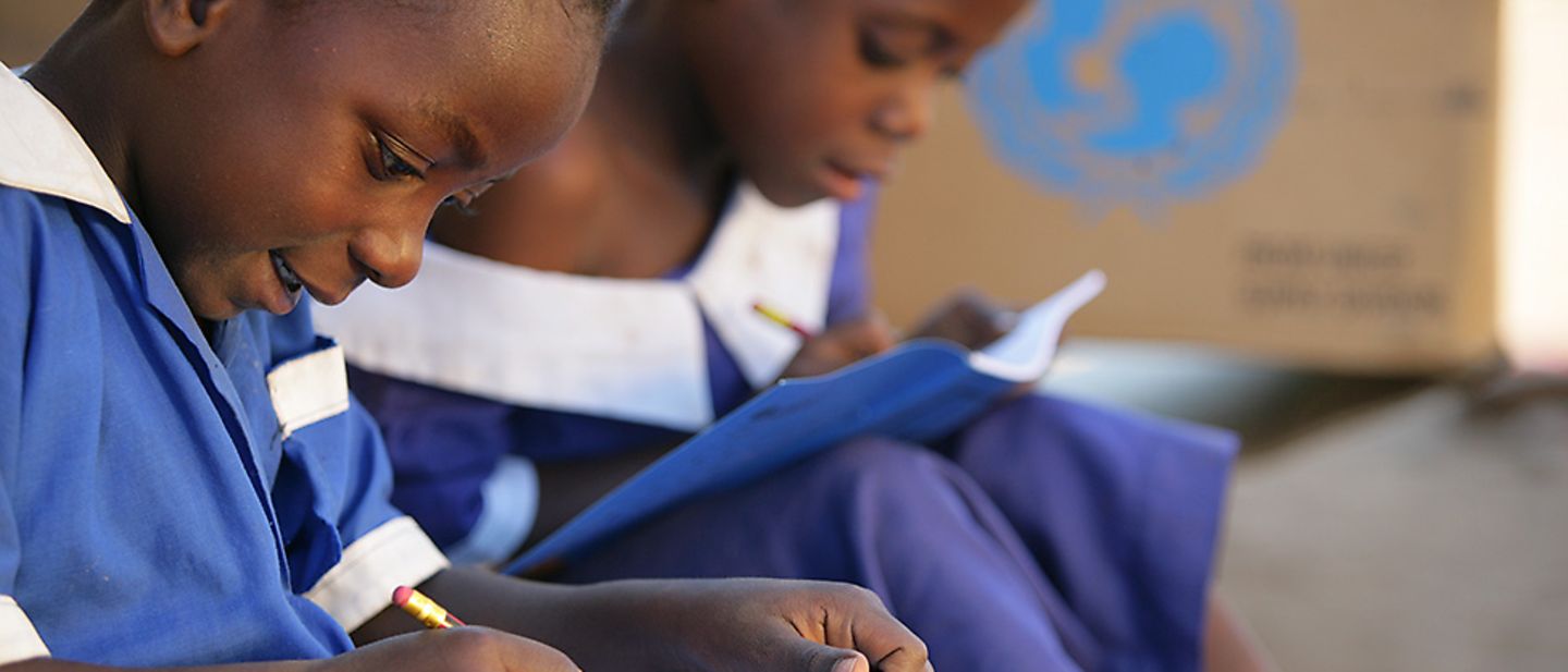 Malawi: Zwei Schulkinder schreiben in ihre neuen UNICEF-Schulhefte.