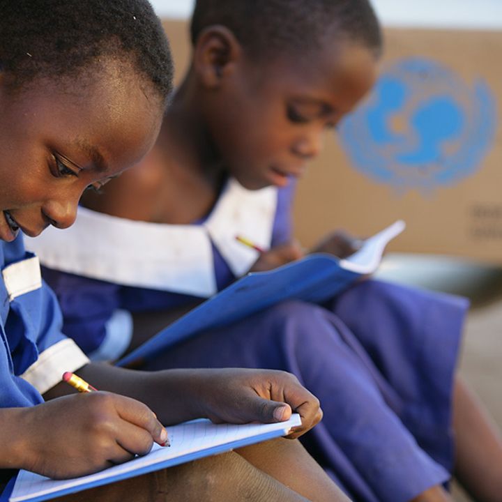 Malawi: Zwei Schulkinder schreiben in ihre neuen UNICEF-Schulhefte.